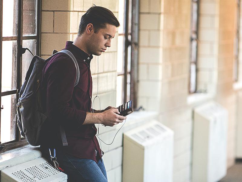 Student holding a wallet illustrating challenge of buying textbooks, affordability