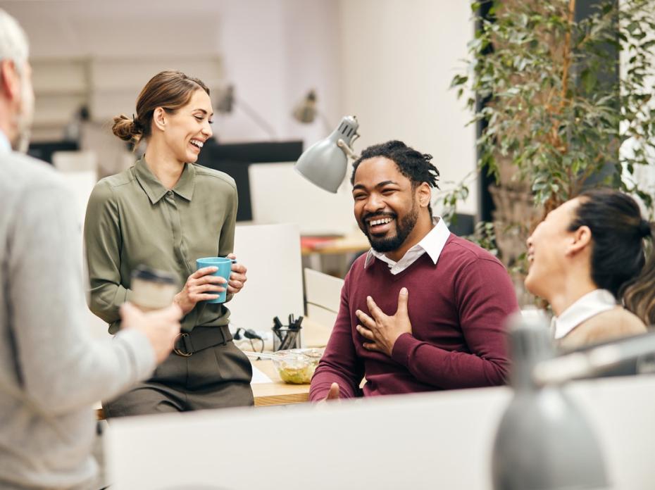 Colleagues laughing and having a chat over coffee