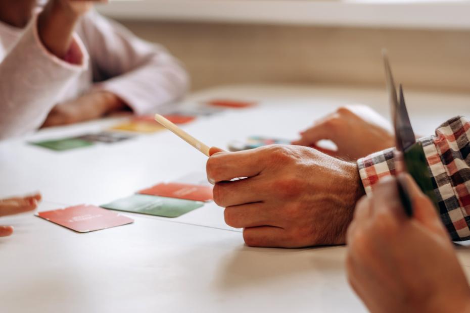 Adults playing a game using cards