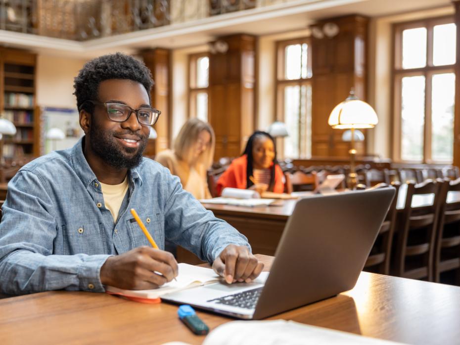 Young man wearing headphones while working on a laptop