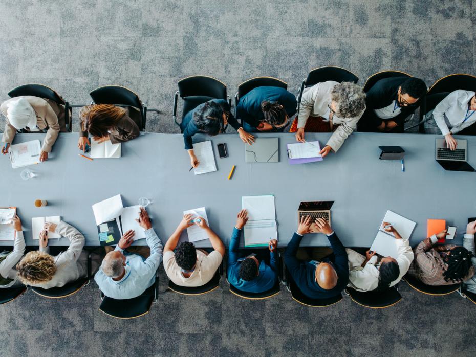 A large team working together at a table - top-down view