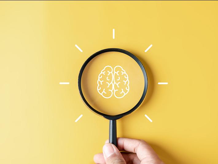 Magnifying glass looking at a brain, illustration