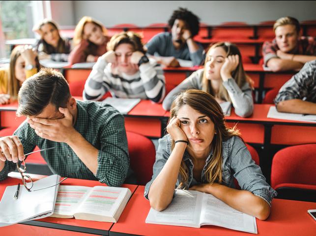 Bored students sit slumped in a lecture hall