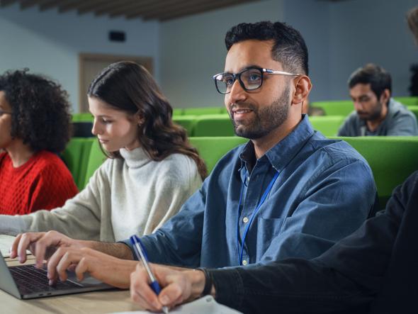 A student uses a laptop in a lecture hall