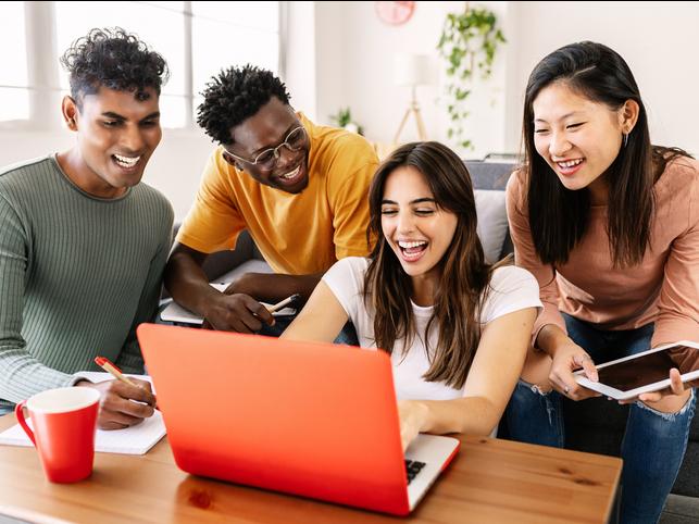 Students gather round a laptop together