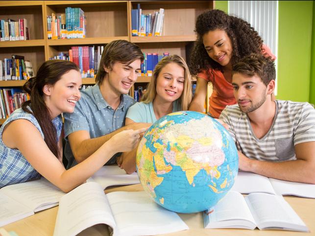 Students point at a globe