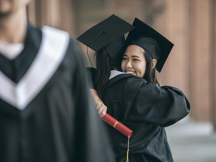 Two female graduates embrace