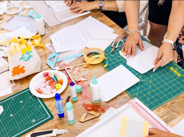 Students using card and paper to create models in class