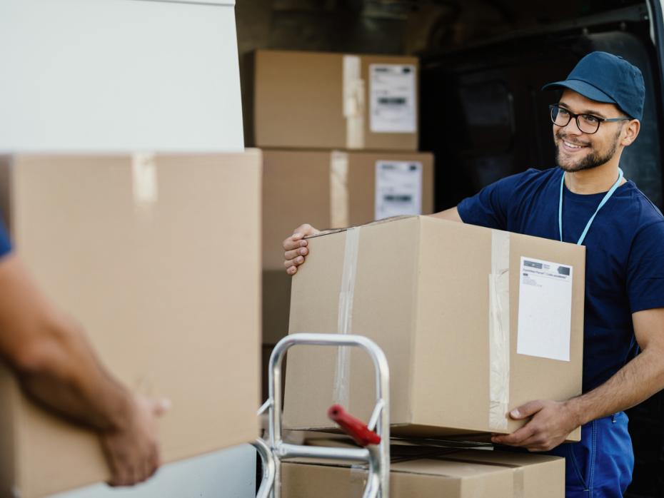 A delivery driver carrying a box 