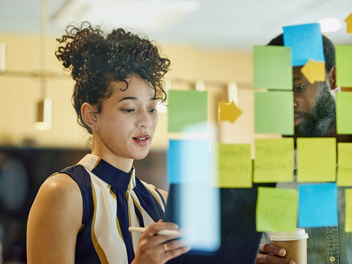 Two professionals using stick notes to plan