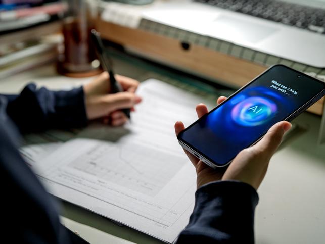 A student uses an AI tool on their phone while working