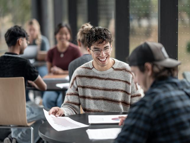 University students sitting at a table discussing a project