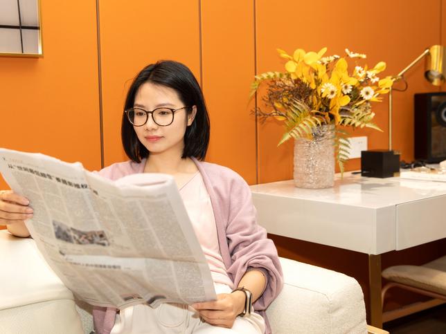 A female university student reading a newspaper