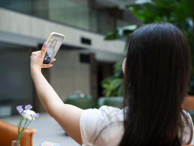 A student filming herself on her phone