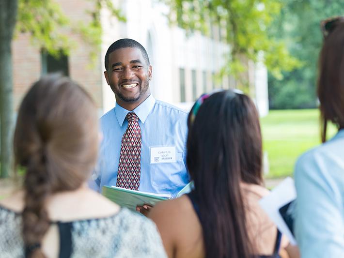 Tour guide showing potential students around university campus