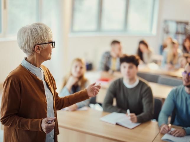 A teacher talks at the front of class
