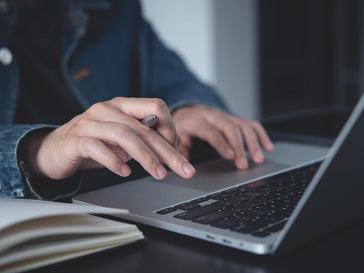 Female student writing on laptop