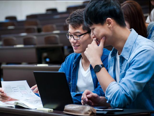 Chinese students working together at a laptop