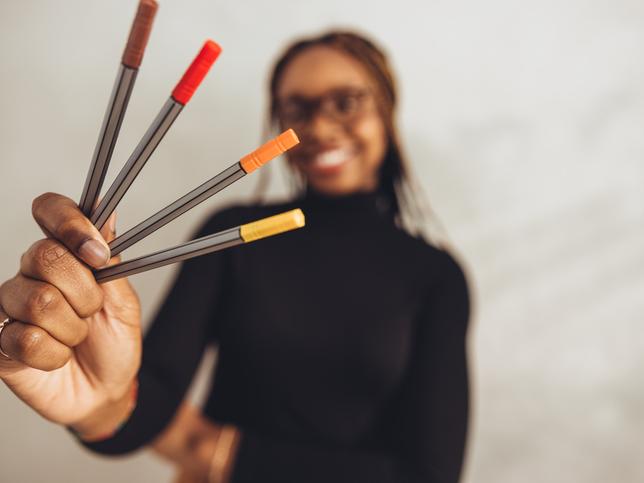 A student holding marker pens