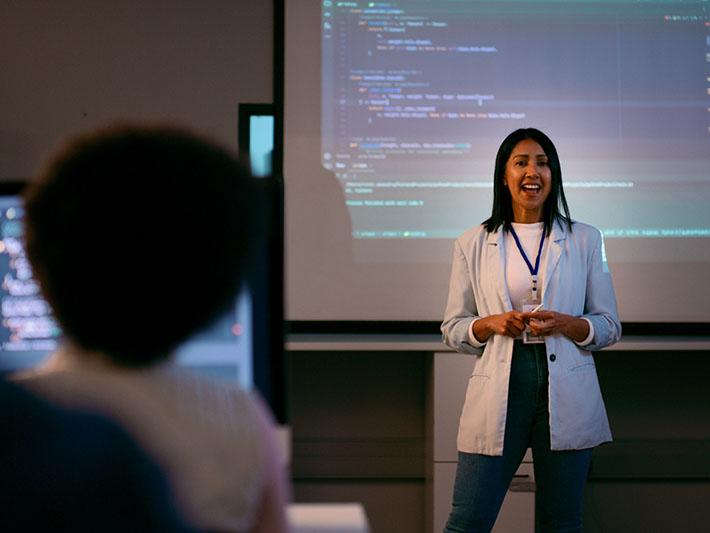 Female instructor in class before screen with code