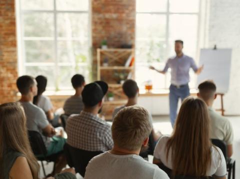 Image of a male teacher hosting a university seminar