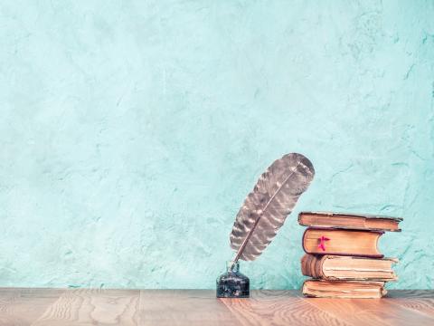 Ink quill and old books 