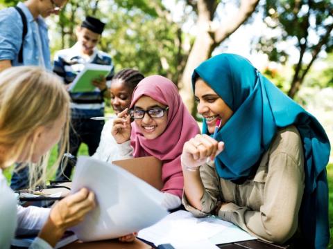 Indonesian students sitting outside on campus