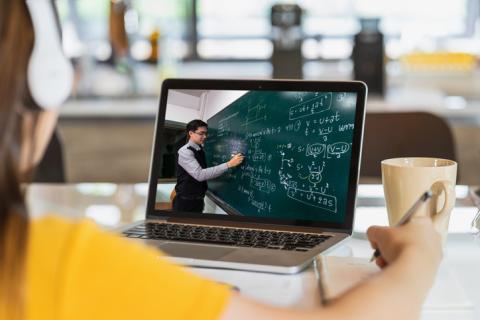 high school student watching remote mathematics lecture on laptop