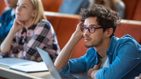 A bored looking student in a lecture