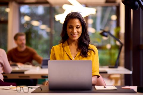 Female academic on her laptop receiving news about a promotion to an academic administration role