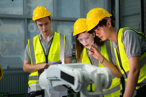 Three young engineers in hazard gear