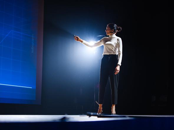 Young woman on stage giving a presentation