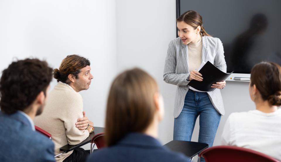 A young female professor talking to students in class