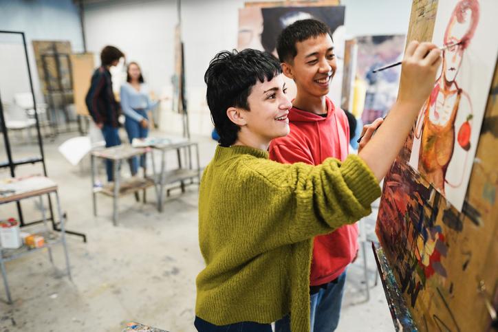 Young multiracial artists painting in a studio