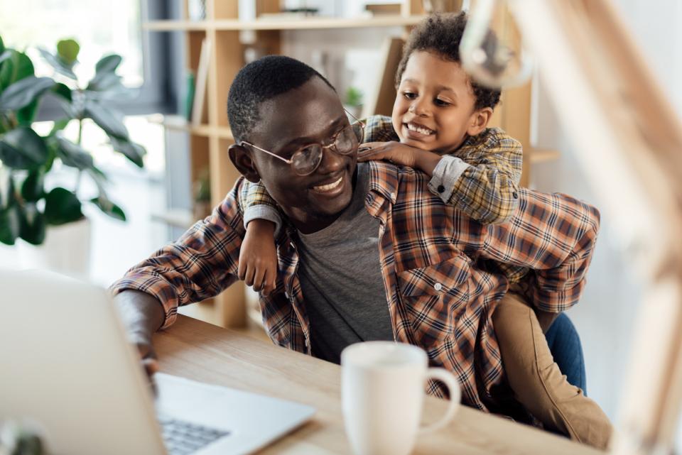 Father with his child at a laptop working 