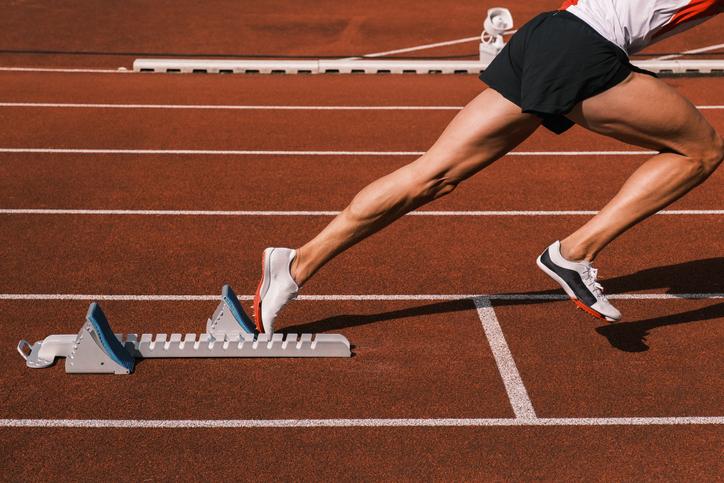 A runner starts a race, pushing out from blocks