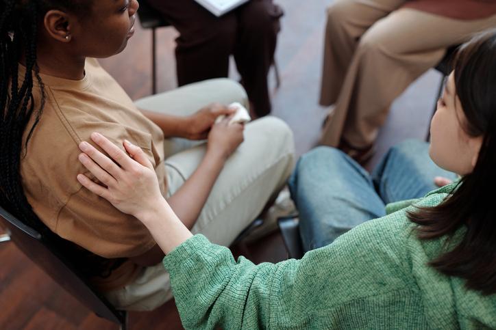 One student comforts another with a hand on the shoulder