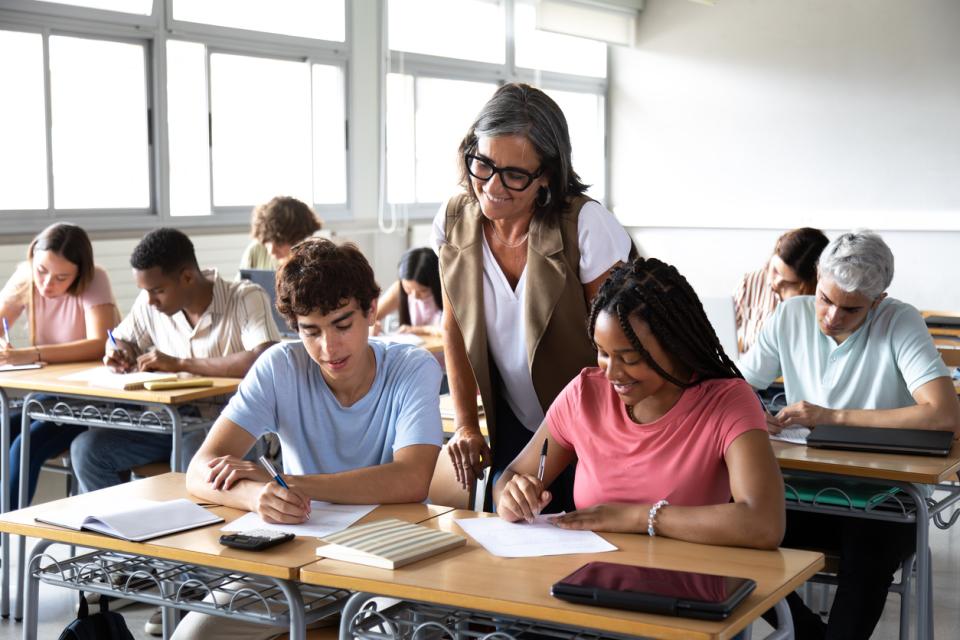 A teacher helping students with their work in class