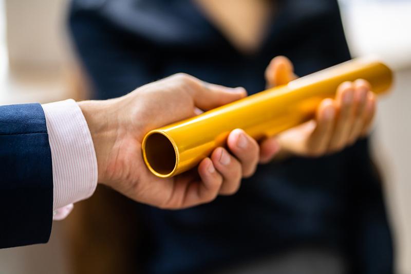 Buinessmen passing a gold baton