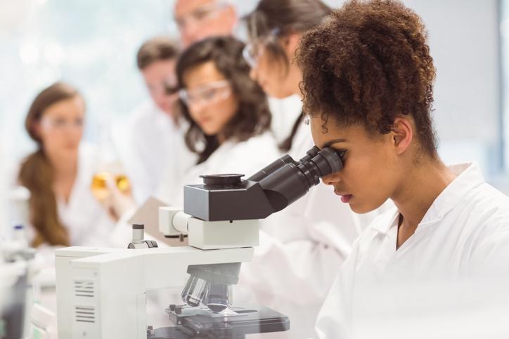 A student uses a microscope in a lab