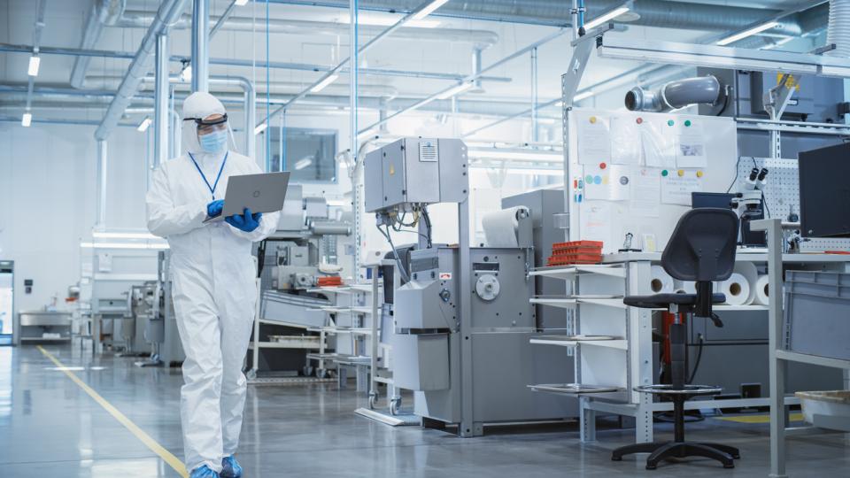 A technician holding a laptop in a lab