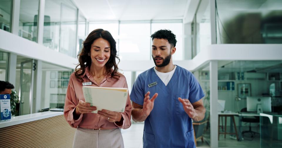 Two healthcare professionals consulting a document