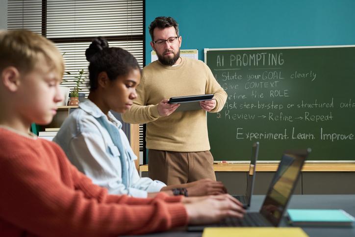 A teacher works with students on GenAI literacy
