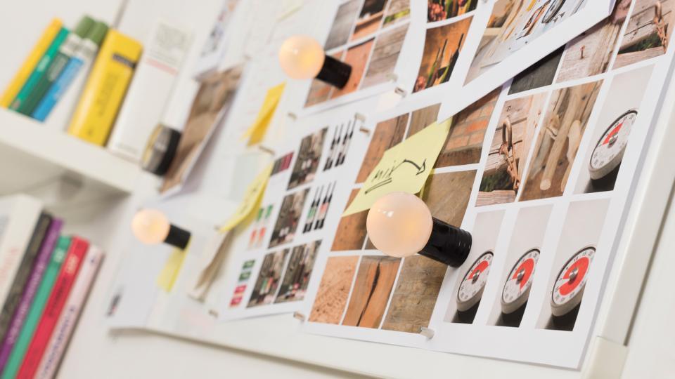 Whiteboard with photographs and sticky notes on a magnetic wall