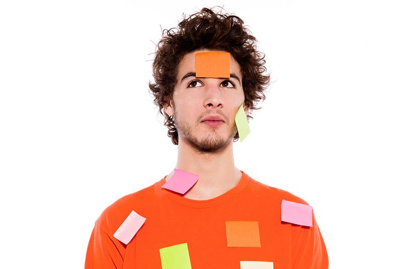 Young man covered in sticky labels