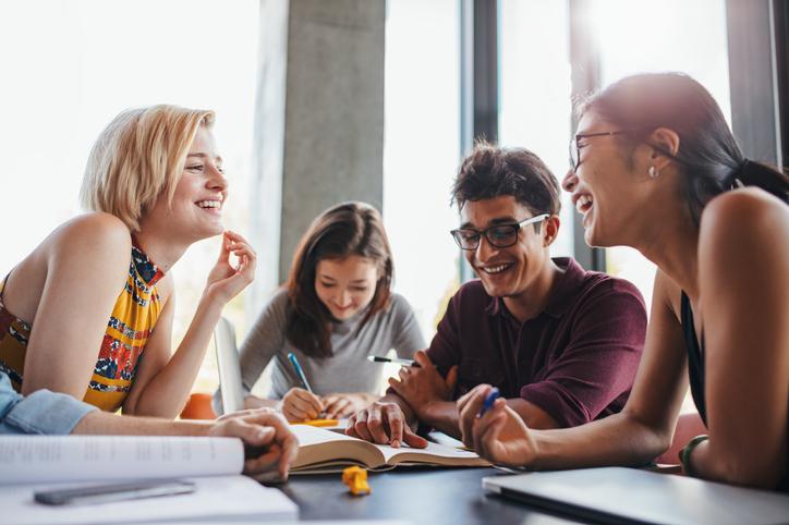 Students laugh together over textbooks