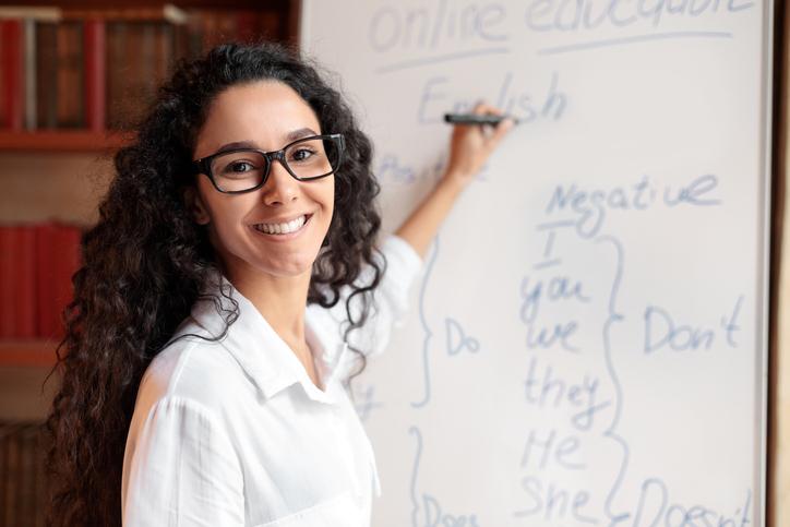 A teacher writes on a whiteboard