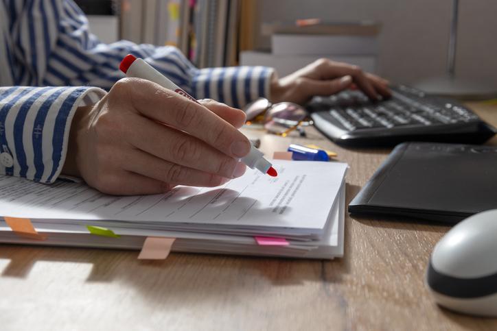 A reviewer wields a red pen