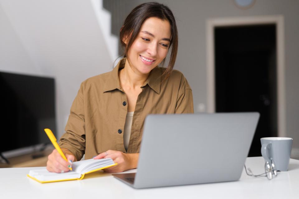 An academic writing a journal article on her laptop