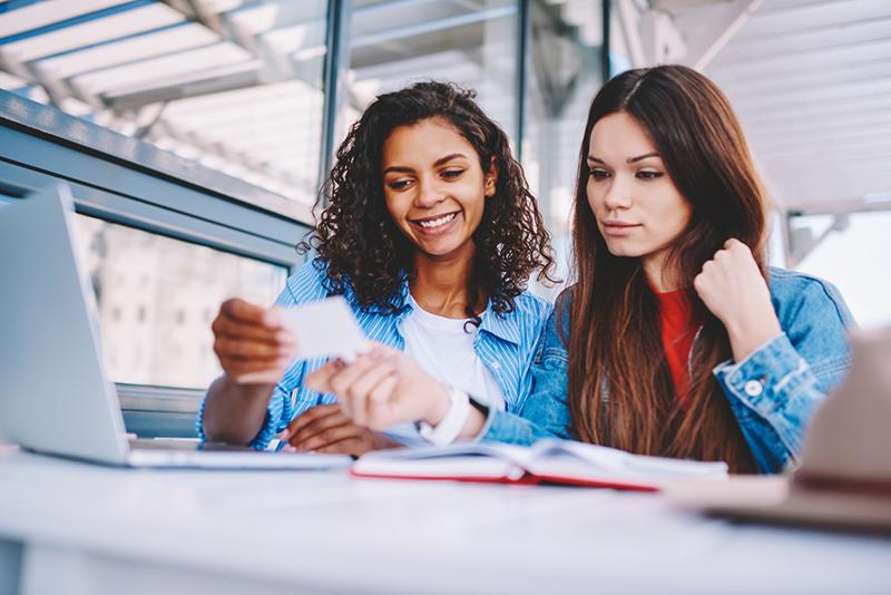 Two female students looking at a flash card